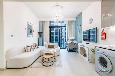 a living room with a white couch and a table at Charming 1BR Apartment in Azizi Riviera 30, Al Merkadh by Deluxe Holiday Homes in Dubai