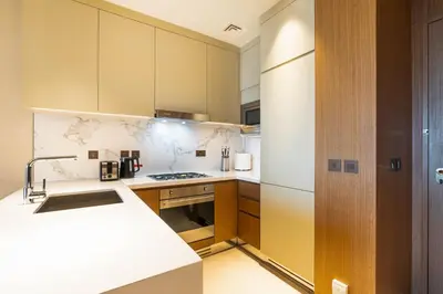 a kitchen with a sink and a stove top oven at Deluxe Address Opera Home with Full Sea View in Dubai
