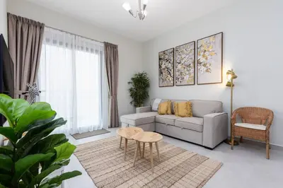 a living room with a couch and a table at Waves - Stylish 1BR Close to IMG World & Global Village in Dubai