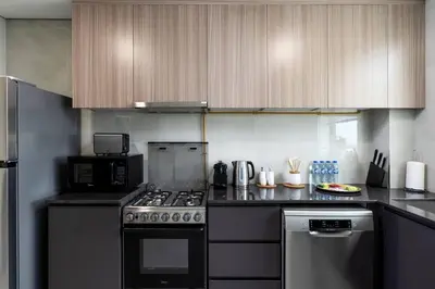 a kitchen with a stove and a microwave at Waves - Stylish 1BR Close to IMG World & Global Village in Dubai