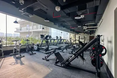 a gym with a bunch of treadms and cardio machines at Waves - Stylish 1BR Close to IMG World & Global Village in Dubai