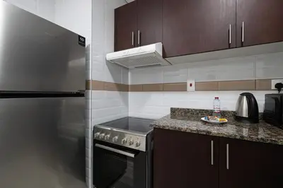a kitchen with a stove and a refrigerator at Luxurious 1BR in Court Tower Business Bay in Dubai