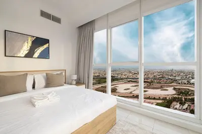 a bedroom with a large white bed and a large window at Luxurious 1BR in Court Tower Business Bay in Dubai