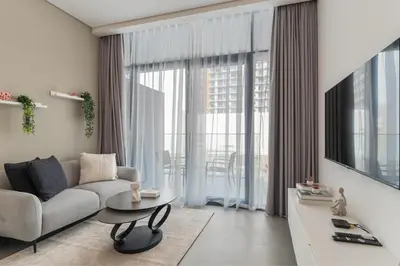 a living room with a couch and a table at HAVN - Smart Home Studio in Oxford Terraces, JVC in Dubai