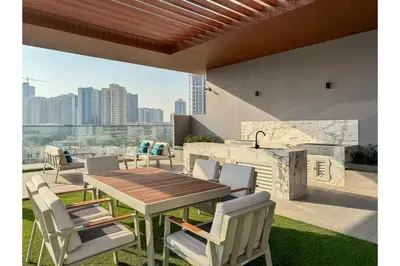 a table and chairs on a patio with a view at HAVN - Smart Home Studio in Oxford Terraces, JVC in Dubai