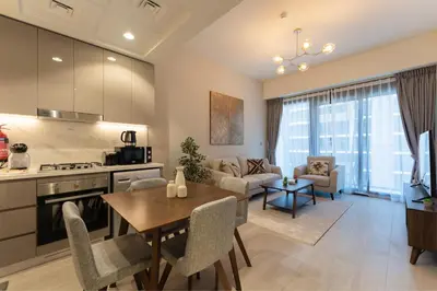 a kitchen and living room with a table and a dining room at HAVN - 1 Bedroom Unit in Azizi Riviera, Meydan in Dubai