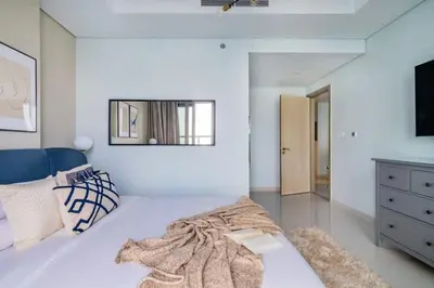 a white room with a bed and a mirror at Stunning Burj Views - Highest Infiniti Pool in Dubai