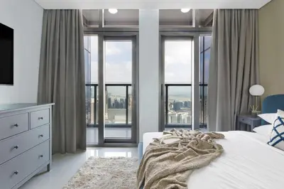 a bedroom with a white bed with a large window at Stunning Burj Views - Highest Infiniti Pool in Dubai
