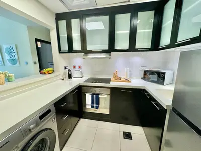 a kitchen with a sink and a dishwasher in it at Modern 1BR with Balcony, Pool and Gym, Dubai Marina in Dubai
