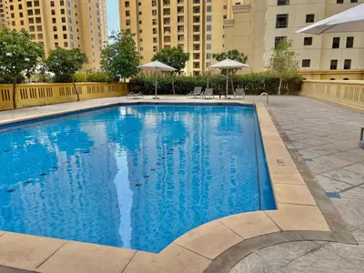 a large blue swimming pool with buildings in the background at High Floor 1BR Apartment with breathtaking sea views of AIN Dubai in Dubai