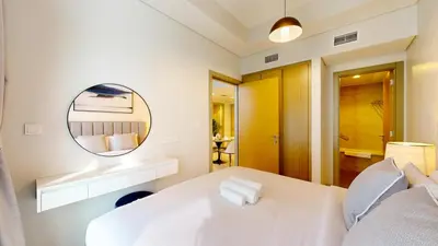 a white bedroom with a bed and a mirror at Vacationer I Elegant 2 Bedroom I Business Bay I Central & Convenient I Aykon City Tower in Dubai