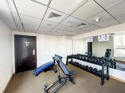 a room with a gym with chairs and a treadmill at Bay Central - One Bedroom with Marina View in Dubai