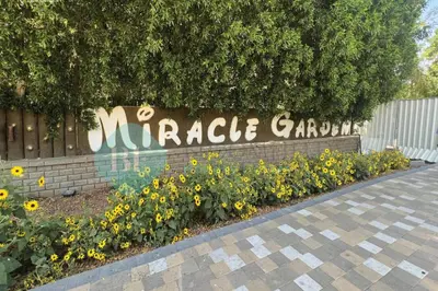 a sign for a miracle garden with yellow flowers at Bloomfields Hidden Gem Studio In Arjan in Dubai