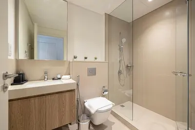a bathroom with a shower and a toilet and a sink at Stunning Two-Bedroom Apartment with Skyline View & walk to Dubai Mall by TerraHome in Dubai