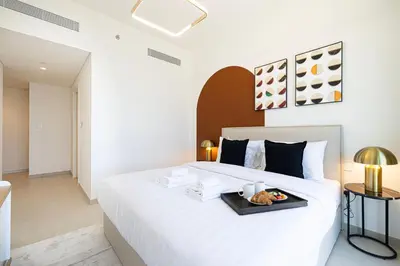a bedroom with a bed with a tray of food on it at Stunning Two-Bedroom Apartment with Skyline View & walk to Dubai Mall by TerraHome in Dubai
