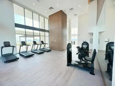a gym with a row of treadmills and machines at Farhad Azizi Residence - Al Jaddaf by Golden Casa in Dubai