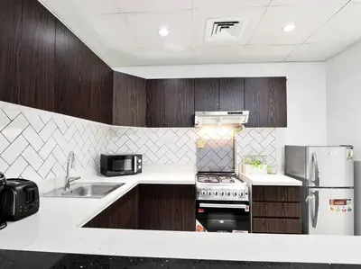 a kitchen with a sink and a stove and refrigerator at StoneTree - Fully Furnished - Dania 2 in Dubai