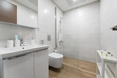 a white bathroom with a toilet and a sink at StoneTree - Newly Furnished - Al Furjan in Dubai
