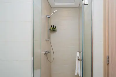 a shower with a glass door in a bathroom at Elite Escape - 1 BHK Getaway in Azizi Riviera in Dubai