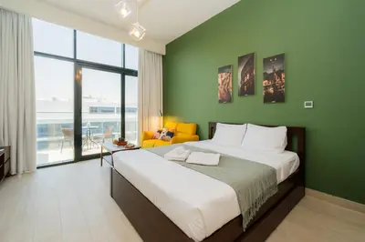 a bedroom with a large bed with a green wall at Elite Escape - 1 BHK Getaway in Azizi Riviera in Dubai