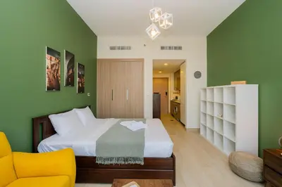a bedroom with a large bed and a yellow chair at Elite Escape - 1 BHK Getaway in Azizi Riviera in Dubai