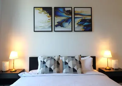 a bedroom with four pictures on the wall and a bed at Luminous 2 BR - Sobha Reserve in Dubai