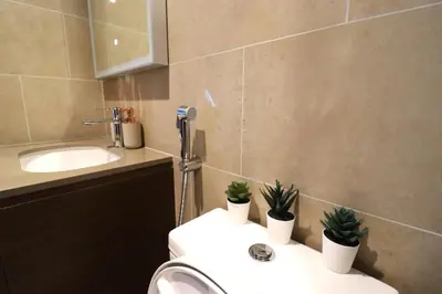 a bathroom with a sink and a toilet with plants on it at Luminous 2 BR - Sobha Reserve in Dubai