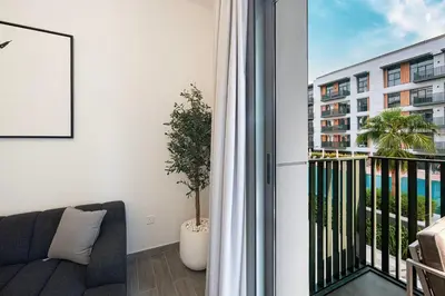 a balcony with a couch and a view of a building at Sophisticated 1BR with Pool View in Belgravia Square JVC in Dubai