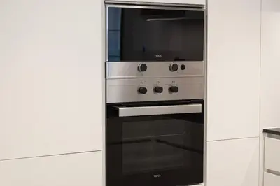 a stainless steel oven in a white kitchen at Sophisticated 1BR with Pool View in Belgravia Square JVC in Dubai