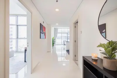 a hallway with white walls and a mirror at Serenity Living - stunning 1BR, DAMAC Hills in Dubai