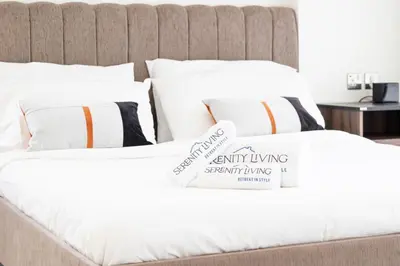 two beds with white sheets and a sign on them at Serenity Living - stunning 1BR, DAMAC Hills in Dubai