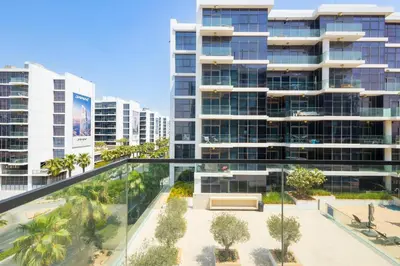 an aerial view of a building with palm trees at Serenity Living - stunning 1BR, DAMAC Hills in Dubai