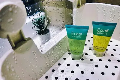 two bottles of e eco batteries sitting on a sink at Chic and Cozy Studio in Dubai