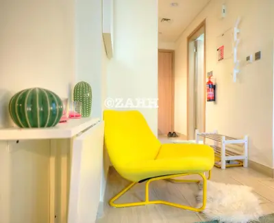 a yellow chair in a room with a table at Cozy Crib in Dubai
