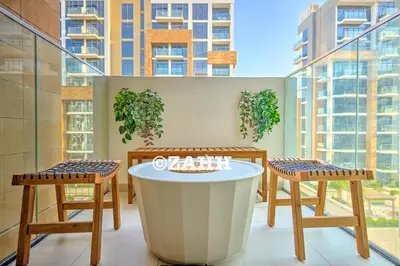 a table and two chairs in a room with a large window at Cozy Crib in Dubai