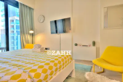 a bedroom with a yellow and white bed and yellow chairs at Cozy Crib in Dubai