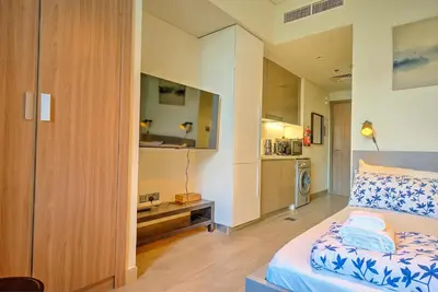 a small room with a bed and a kitchen at Paradise Point in Dubai