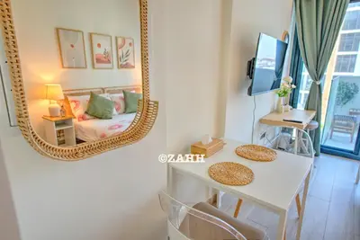 a room with a mirror and a table and a couch at Studio Haven in Dubai