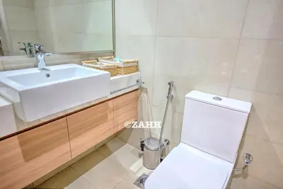 a bathroom with a white sink and a toilet at Studio Haven in Dubai