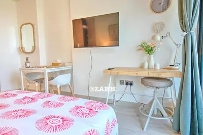 a room with a bed and a table and a refrigerator at Studio Haven in Dubai