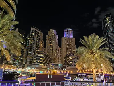 a city skyline at night with palm trees and buildings at New Horizon 2 Bedroom LUXURY APARTMENT JBR MARINA in Dubai