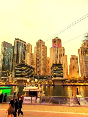 a group of people walking along a river with a large city at New Horizon 2 Bedroom LUXURY APARTMENT JBR MARINA in Dubai