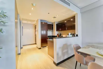 a kitchen and dining room with a table and chairs at Palm Paradise 1BR - Beachfront Escape with Pool, Gym, Parking & Balcony in Dubai