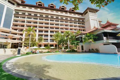 a hotel with a swimming pool in front of a building at Palm Paradise 1BR - Beachfront Escape with Pool, Gym, Parking & Balcony in Dubai