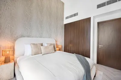 a bedroom with a large white bed and two lamps at Daniels 1BR at Creek Edge with Waterfront View in Dubai
