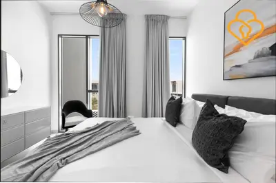 a bedroom with a white bed and a chair at Keysplease 4BR Villa walking to pool, Cherrywoods Family Community in Dubai