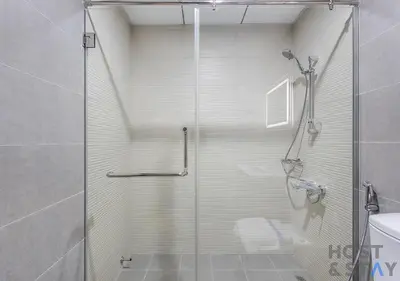 a shower with a glass door in a bathroom at Elegant 1BR Getaway in Bella Rose, Al Barsha in Dubai