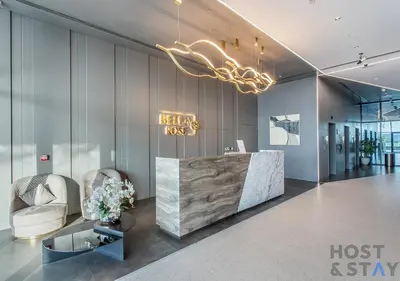 a lobby with a reception desk and chairs and a chandelier at Elegant 1BR Getaway in Bella Rose, Al Barsha in Dubai