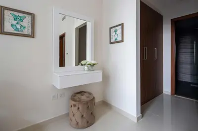 a bathroom with a sink and a mirror and a stool at Frank Porter - Dunya Tower in Dubai