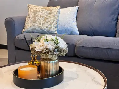 a coffee table with a vase of flowers on a couch at 1 Bedroom with Canal View - 15 Northside in Dubai